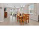 Inviting dining room features a wooden table, tile flooring, and large windows overlooking the backyard at 6051 Sw 93Rd Cir, Ocala, FL 34481