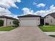 Charming single-story home with a two-car garage and well-maintained landscaping, set beneath a bright, cloudy sky at 6051 Sw 93Rd Cir, Ocala, FL 34481