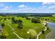 Scenic aerial view of a well-maintained golf course with lush fairways, mature trees, and a tranquil pond at 6051 Sw 93Rd Cir, Ocala, FL 34481