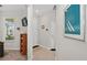 Bright hallway with tiled floors, a large window, and view of a nautical art piece at 6051 Sw 93Rd Cir, Ocala, FL 34481