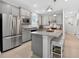 Bright kitchen features an island with seating, stainless steel appliances, and gray cabinets at 6051 Sw 93Rd Cir, Ocala, FL 34481