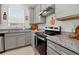 Modern kitchen features gray cabinets, granite countertops, and stainless steel appliances at 6051 Sw 93Rd Cir, Ocala, FL 34481