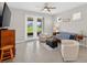 Cozy living room has tile floors, a ceiling fan, and access to the lanai through sliding glass doors at 6051 Sw 93Rd Cir, Ocala, FL 34481