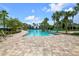 Stunning community pool area featuring spacious deck, swaying palms, and inviting clear blue water at 6051 Sw 93Rd Cir, Ocala, FL 34481