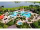 Aerial view of luxurious community pool, poolside seating, lush landscaping, and serene lakefront views at 6051 Sw 93Rd Cir, Ocala, FL 34481