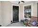 Cozy porch featuring a black front door with wreath and a chair next to a large window at 6051 Sw 93Rd Cir, Ocala, FL 34481