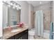 Bright bathroom featuring a granite countertop, a decorative mirror, and a shower with patterned curtain at 7210 Sw 179 Ct, Dunnellon, FL 34432