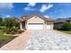 Charming home with a red tile roof, three-car garage, and a beautifully paved driveway at 7210 Sw 179 Ct, Dunnellon, FL 34432