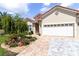 Beautiful home exterior showcasing a two-car garage and brick-paved driveway at 7210 Sw 179 Ct, Dunnellon, FL 34432