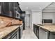 Modern kitchen featuring stainless steel appliances, granite countertops, and dark cabinets at 7210 Sw 179 Ct, Dunnellon, FL 34432