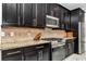Close-up of a modern kitchen, showcasing stainless steel appliances and sleek dark cabinetry at 7210 Sw 179 Ct, Dunnellon, FL 34432