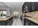Kitchen features stainless steel appliances, granite countertops, and dark cabinetry, flowing into dining area at 7210 Sw 179 Ct, Dunnellon, FL 34432