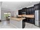 Modern kitchen with dark cabinetry, stainless steel appliances, and a large center island at 7210 Sw 179 Ct, Dunnellon, FL 34432