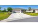 Landscaped front yard with mature trees and green lawn leading to a single-story home with a two-car garage at 7750 Sw 87Th Ave, Ocala, FL 34481