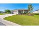 Inviting single-Gathering home with a well-kept lawn, colorful landscaping, and a spacious driveway leading to the garage at 7750 Sw 87Th Ave, Ocala, FL 34481