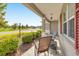 Cozy front porch featuring outdoor seating, decorative lights, and charming curb appeal with lush landscaping at 7750 Sw 87Th Ave, Ocala, FL 34481