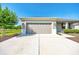 Exterior showcasing a two-car garage, lush front lawn, and well-maintained landscaping on a sunny day at 7750 Sw 87Th Ave, Ocala, FL 34481