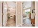 Hallway showcasing a bathroom with a shower and vanity, and a glimpse into a cozy bedroom with natural light at 7750 Sw 87Th Ave, Ocala, FL 34481