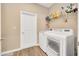 Bright laundry room with modern washer and dryer, storage shelf, and wood-look flooring at 7750 Sw 87Th Ave, Ocala, FL 34481