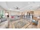 Open-concept living room with tray ceilings, ceiling fan, wood-look flooring, and kitchen views at 7750 Sw 87Th Ave, Ocala, FL 34481