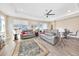 Spacious living room features tray ceilings, a ceiling fan, and wood-look floors at 7750 Sw 87Th Ave, Ocala, FL 34481
