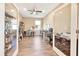 Bright home office featuring glass doors, shelving, wood-look flooring, and a ceiling fan at 7750 Sw 87Th Ave, Ocala, FL 34481