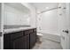 Bathroom featuring sleek black cabinets, granite countertop, and a shower-tub combo at 8110 Sw 59Th Ter, Ocala, FL 34476