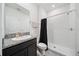 A full bathroom with a walk-in shower, granite countertop, and neutral gray tile flooring at 8110 Sw 59Th Ter, Ocala, FL 34476