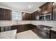 Modern kitchen with dark cabinets, granite countertops, and stainless steel appliances at 8110 Sw 59Th Ter, Ocala, FL 34476