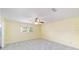 Bright bedroom features a ceiling fan, neutral carpet, and a window with plantation shutters at 8745 Sw 92Nd St # B, Ocala, FL 34481