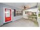 Inviting front porch featuring a ceiling fan, red front door, and black window shutters at 8745 Sw 92Nd St # B, Ocala, FL 34481