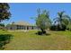 Expansive backyard with healthy green grass, mature landscaping, and the rear of a light colored home at 9068 Se 120Th Loop, Summerfield, FL 34491