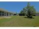 Spacious backyard featuring lush green grass, mature trees, and partial views of neighboring houses at 9068 Se 120Th Loop, Summerfield, FL 34491