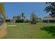 A spacious backyard with a lush lawn, mature trees, and an enclosed patio area on one of the homes at 9068 Se 120Th Loop, Summerfield, FL 34491