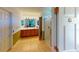 Bright bathroom featuring double sinks, a wooden vanity, a framed mirror, and a glass-enclosed shower at 9068 Se 120Th Loop, Summerfield, FL 34491