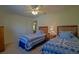 Bedroom with matching twin beds, ceiling fan, and side table with a lamp, providing a comfortable space at 9068 Se 120Th Loop, Summerfield, FL 34491