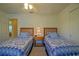 Bright bedroom featuring twin beds, ceiling fan, and a view into the hallway, creating a cozy atmosphere at 9068 Se 120Th Loop, Summerfield, FL 34491