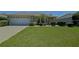Welcoming single-story home showcasing a well-maintained lawn, an attached two-car garage and manicured landscaping at 9068 Se 120Th Loop, Summerfield, FL 34491