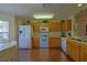 Well-lit eat-in kitchen with wood cabinets and modern appliances featuring a large countertop at 9068 Se 120Th Loop, Summerfield, FL 34491