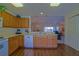 Open kitchen featuring wooden cabinets, modern appliances, and hardwood floors leading into an open living area at 9068 Se 120Th Loop, Summerfield, FL 34491