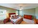 Spacious bedroom with large windows, a ceiling fan, and a dresser, creating a bright and relaxing retreat at 9068 Se 120Th Loop, Summerfield, FL 34491