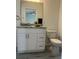 Bathroom features vanity with a granite counter, a toilet, updated hardware and lighting fixtures at 960 Nw Redwood Dr, Dunnellon, FL 34431