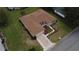 Aerial view of a tan home with well-manicured lawn, mature landscaping, and a two-car garage at 9891 Se 138Th Loop, Summerfield, FL 34491