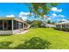 Expansive backyard featuring a well-maintained lawn, screened patio and mature landscaping at 9891 Se 138Th Loop, Summerfield, FL 34491