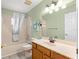 Cozy bathroom featuring neutral tile walls, a shower-tub combo, and a wood vanity with a clean basin at 9891 Se 138Th Loop, Summerfield, FL 34491