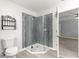 Bathroom features a glass-enclosed shower, tile flooring, and a door to an adjoining room at 9891 Se 138Th Loop, Summerfield, FL 34491