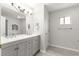 Bright bathroom features a gray vanity with double sinks and a decorative light fixture at 9891 Se 138Th Loop, Summerfield, FL 34491