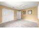 Comfortable bedroom with wall to wall carpet, a ceiling fan, and double door closet providing ample storage at 9891 Se 138Th Loop, Summerfield, FL 34491