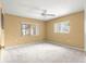Spacious bedroom bathed in natural light from two windows and featuring neutral carpeting at 9891 Se 138Th Loop, Summerfield, FL 34491