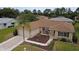 Tan home has a manicured lawn, mulch beds, and seating on the front porch at 9891 Se 138Th Loop, Summerfield, FL 34491